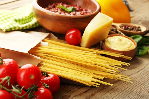 Pasta spaghetti with tomatoes, sauce bolognese, cheese and basil on rustic wooden  background — Stock Photo, Image