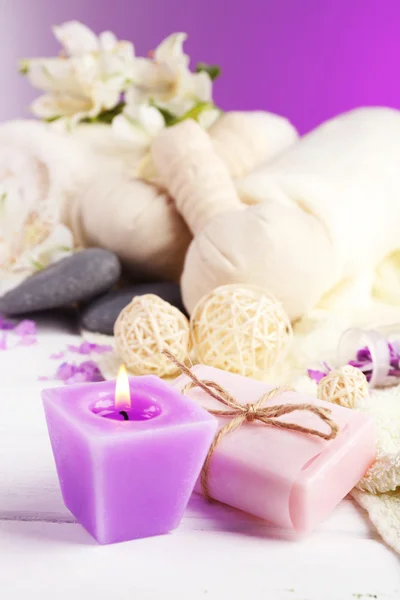 Massagetaschen mit Wellness-Behandlung und Blumen auf Holztischhintergrund — Stockfoto