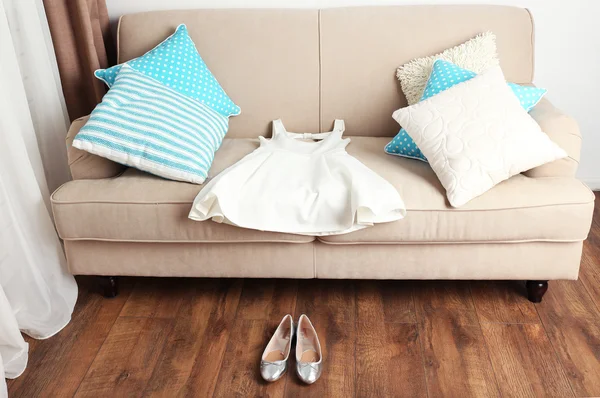 Vestido feminino branco no sofá e sapatos de balé no chão no quarto — Fotografia de Stock
