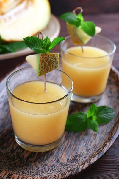 Glasses of melon cocktail on wooden background — Stock Photo, Image