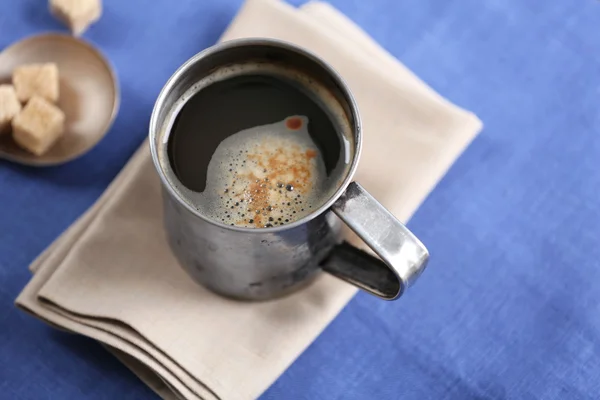 Cangkir logam kopi rasa dengan lump gula dan bunga di atas meja dengan serbet, closeup — Stok Foto