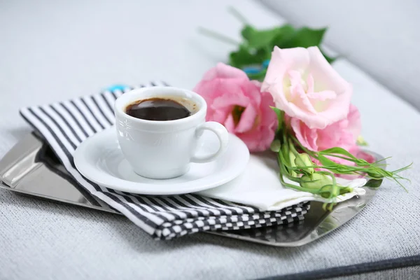 Taza de café con flores en bandeja en el sofá en la habitación —  Fotos de Stock