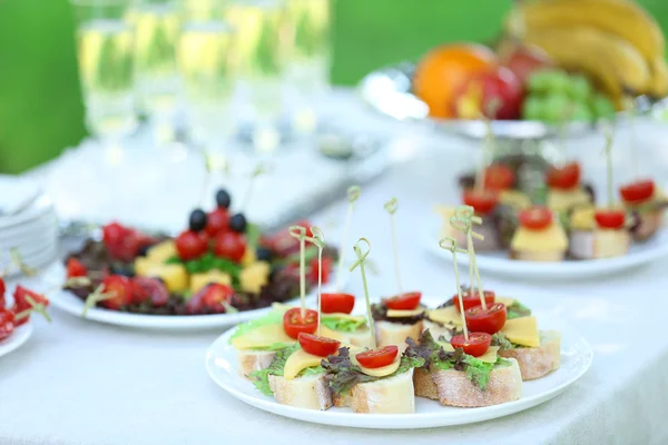 Lanches, frutas e bebidas na mesa, ao ar livre. Conceito de festa jardim — Fotografia de Stock