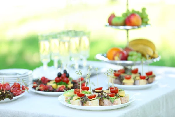 Snacks, fruit en drankjes op tafel, buitenshuis. Tuinfeestje concept — Stockfoto