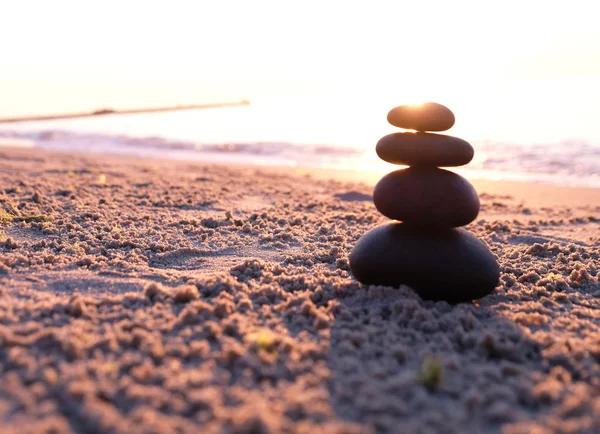 Pirámide de piedras en la playa al atardecer — Foto de Stock