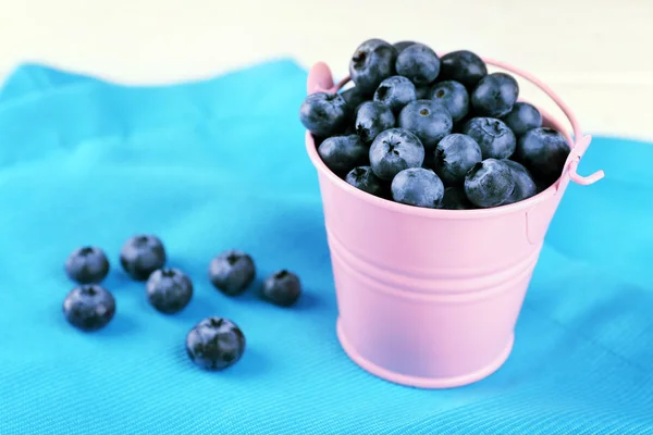 Tasty ripe blueberries in bucket on table close up — Stock Photo, Image