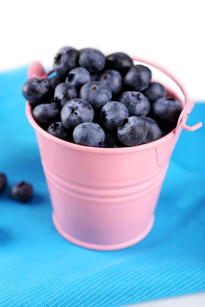 Läckra mogna blåbär i hinken på bordet på nära håll — Stockfoto