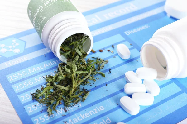 Flaschen mit trockenem medizinischem Cannabis und Tabletten auf dem Tisch — Stockfoto