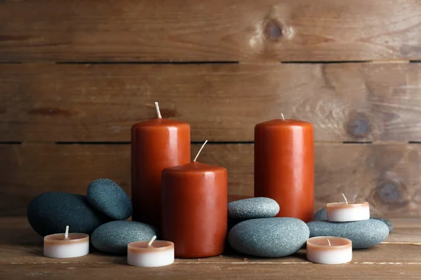 Hermosas piedras de spa con velas sobre fondo de madera —  Fotos de Stock