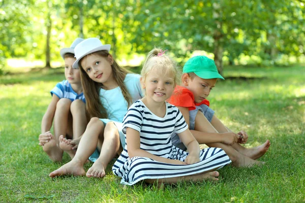 Gelukkige actieve kinderen op groen gras in park — Stockfoto