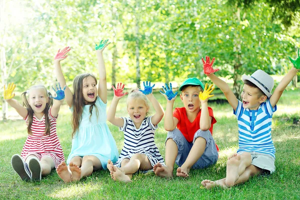 Gelukkige actieve kinderen met helder gekleurde palmen in park — Stockfoto