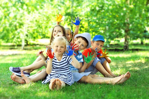 Happy active children with bright colored palms in park — Stock Photo, Image