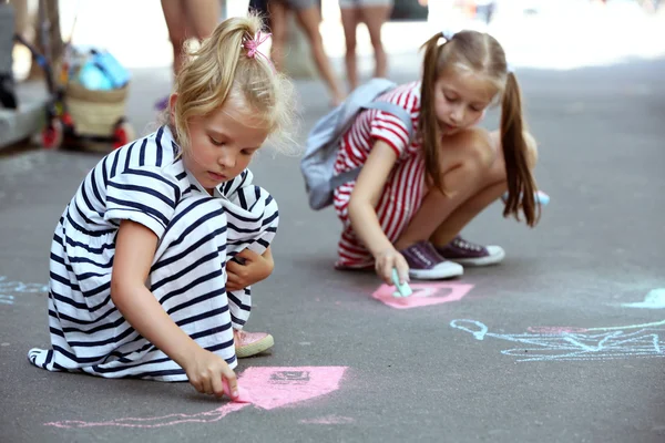 Niños activos felices dibujando con tiza sobre asfalto — Foto de Stock