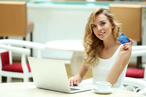 Mulher bonita com laptop e cartão de crédito no café — Fotografia de Stock