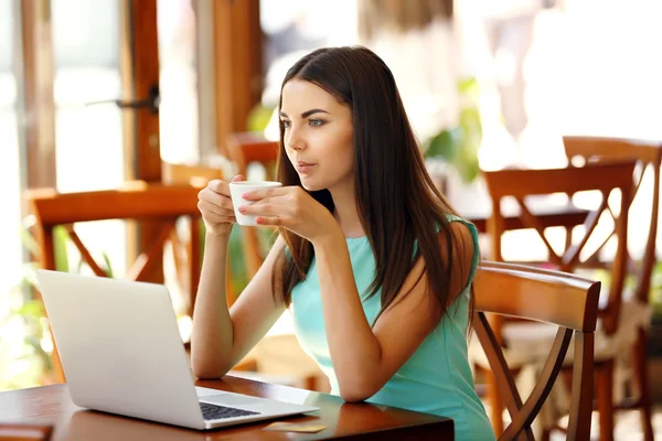 Mooie jonge vrouw met laptop in cafe — Stockfoto