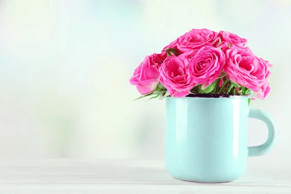 Belles roses en tasse sur fond lumineux — Photo