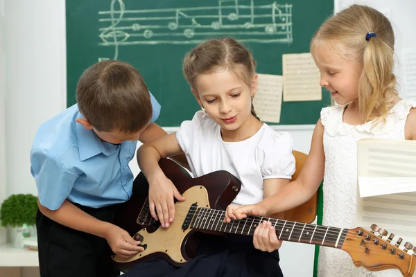Lindos alumnos que tienen clase de música en el aula de la escuela primaria — Foto de Stock