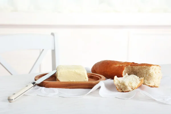 Broken baguette and butter on light background — Stock Photo, Image