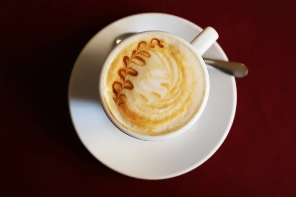 Kopp cappuccino på röd Servett, ovanifrån — Stockfoto