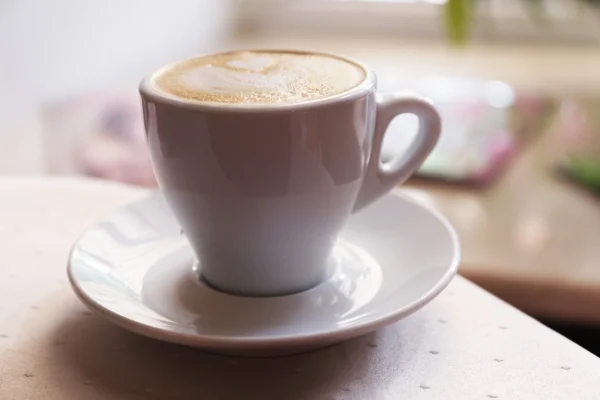 Filiżankę cappuccino na drewnianym stole, zbliżenie — Zdjęcie stockowe