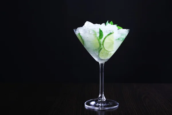 Glass of cocktail with ice on dark background — Stock Photo, Image