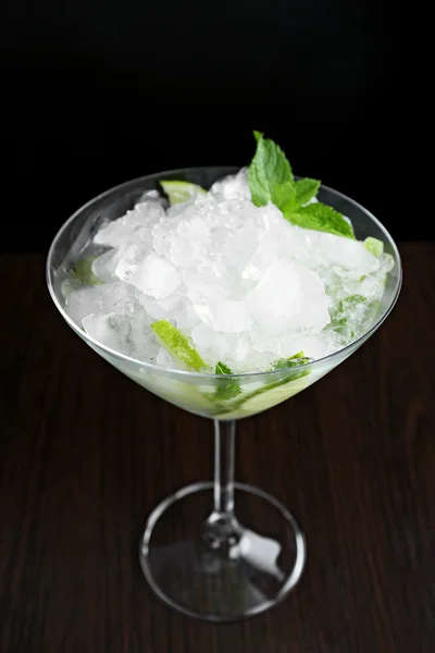 Glass of cocktail with ice on dark background — Stock Photo, Image