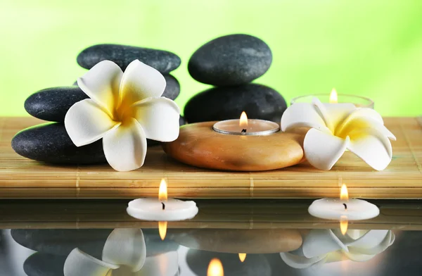 Still life with spa stones on green blurred background — Stock Photo, Image