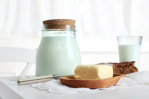 Молоко с хлебом и маслом на столе на кухне — стоковое фото