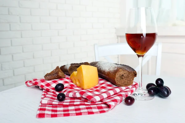 Glas Wein mit Brot und Trauben auf dem Tisch in der Küche — Stockfoto