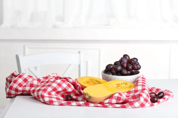 Calabaza y uvas en la mesa en la cocina —  Fotos de Stock