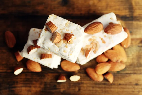 Sweet nougat with almonds on wooden background — Stock Photo, Image