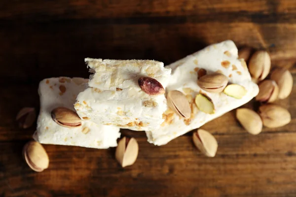 Sweet nougat with pistachios on wooden background — Stock Photo, Image