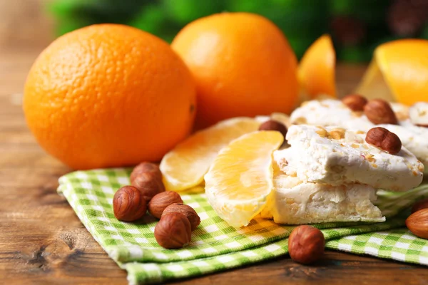 Turrón dulce con avellanas y naranjas en la mesa de cerca —  Fotos de Stock