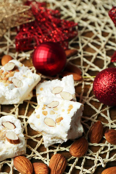 Turrón dulce con almendras y mesa de decoración de Navidad de cerca —  Fotos de Stock