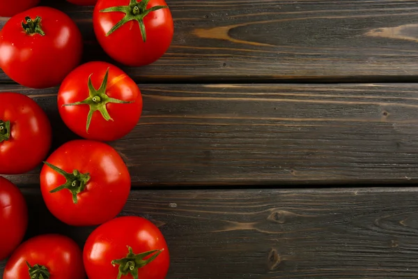 Tomates rojos sobre fondo de madera — Foto de Stock