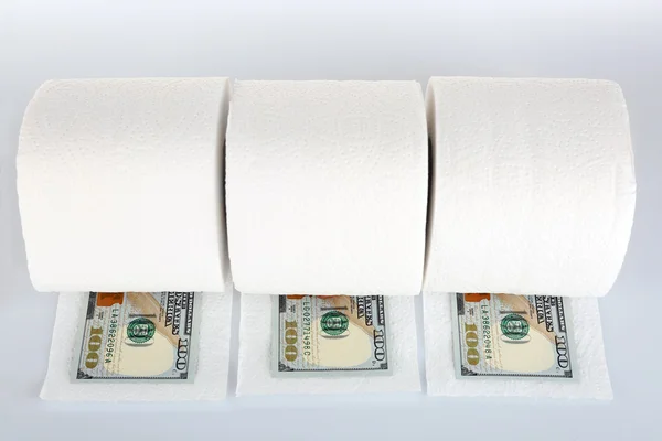 Rolos brancos de papel higiénico e notas de dólar isolados sobre branco — Fotografia de Stock