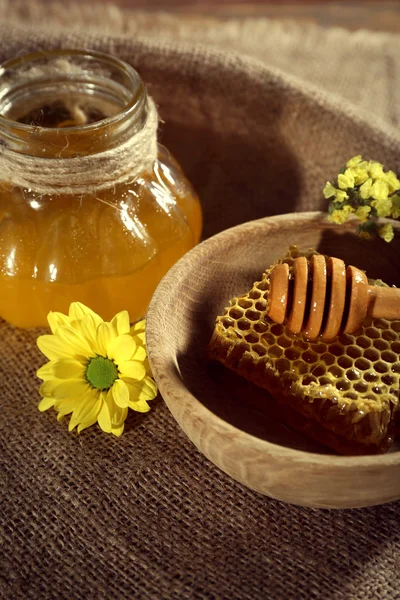 Pot de miel, nid d'abeille et trempette dans un bol sur un sac — Photo