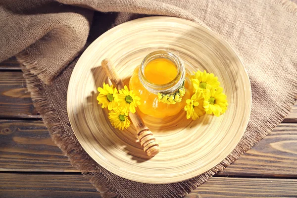 Miel con cazo y flores en bandeja de madera —  Fotos de Stock