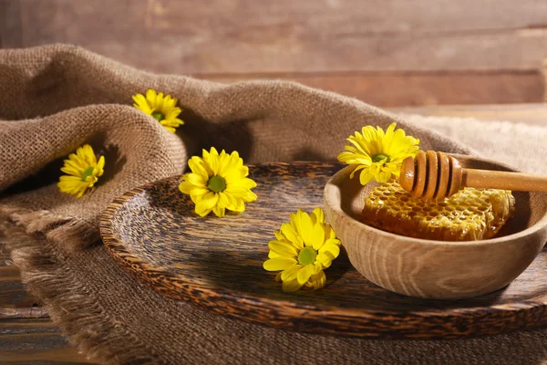 Honeycomb in bowl on tray on wooden table — Stock Photo, Image