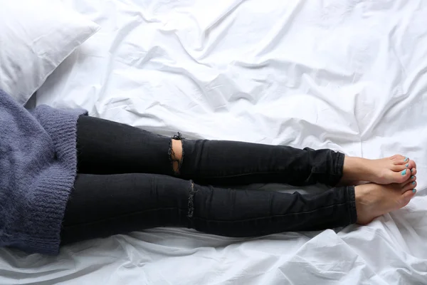 Femme en jean noir sur le point de vue du dessus du lit — Photo
