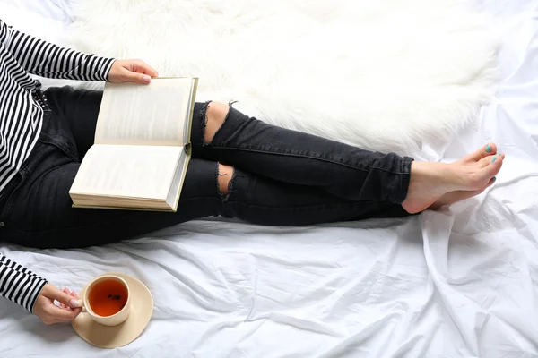 Frau auf dem Bett mit altem Buch und Tasse Kaffee, von oben gesehen — Stockfoto