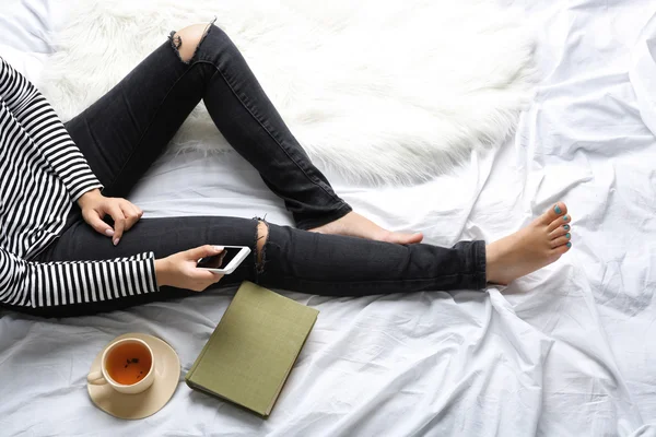 Женщина на кровати со старой книгой и чашкой кофе, вид сверху — стоковое фото