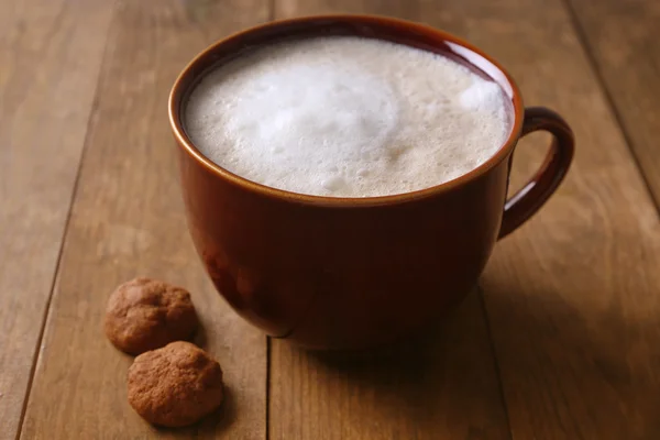 Чашка кави та печива на дерев'яному фоні — стокове фото