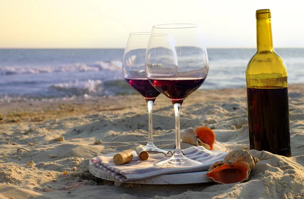 Weinflasche und Gläser am Meeresufer — Stockfoto