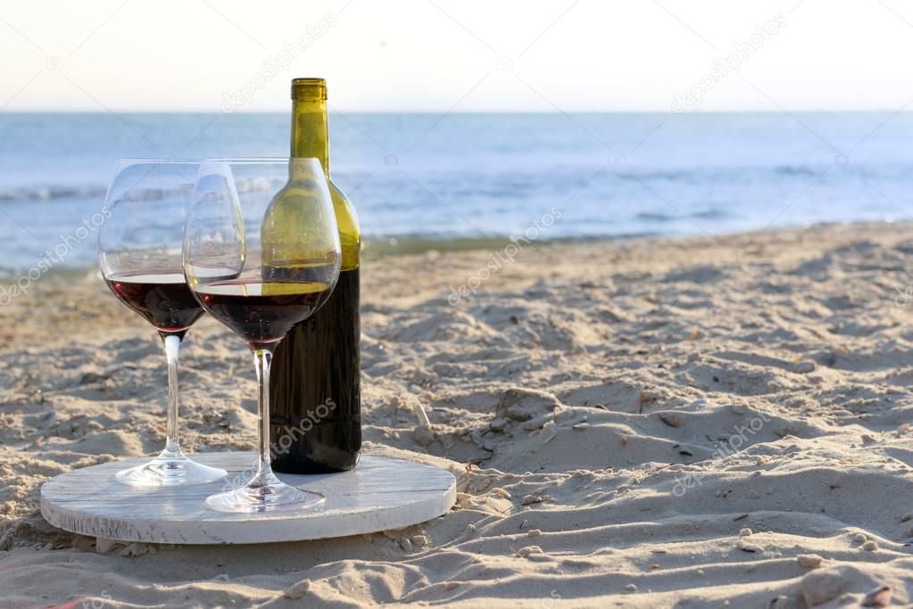 Wine bottle and glasses on the seashore