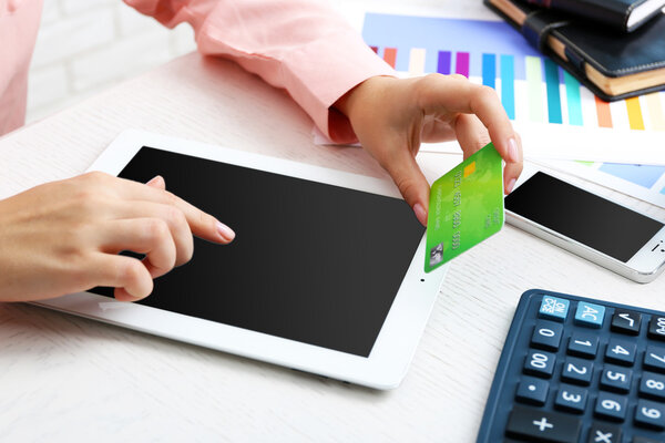 Concept for Internet shopping: hands with digital tablet and credit card