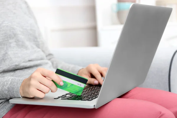 互联网购物的概念: 笔记本电脑和信用卡坐在沙发上，在家里的女人 — 图库照片