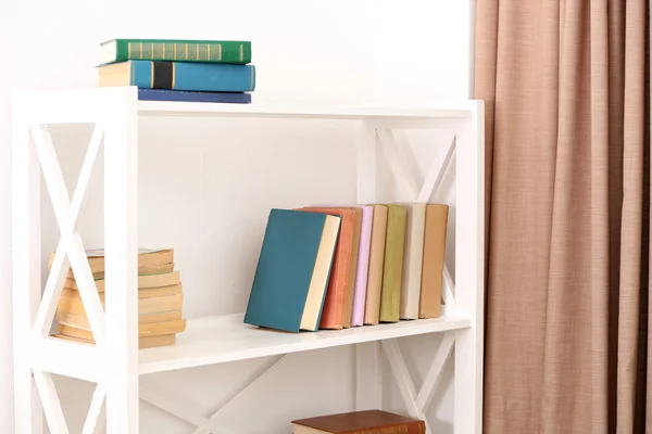 Books on shelves on white wall background — Stock Photo, Image