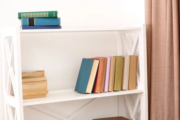 Books on shelves on white wall background — Stock Photo, Image