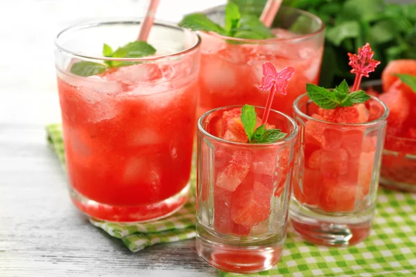 Cold watermelon desserts and drinks in glasses, on wooden table background — Stock Photo, Image
